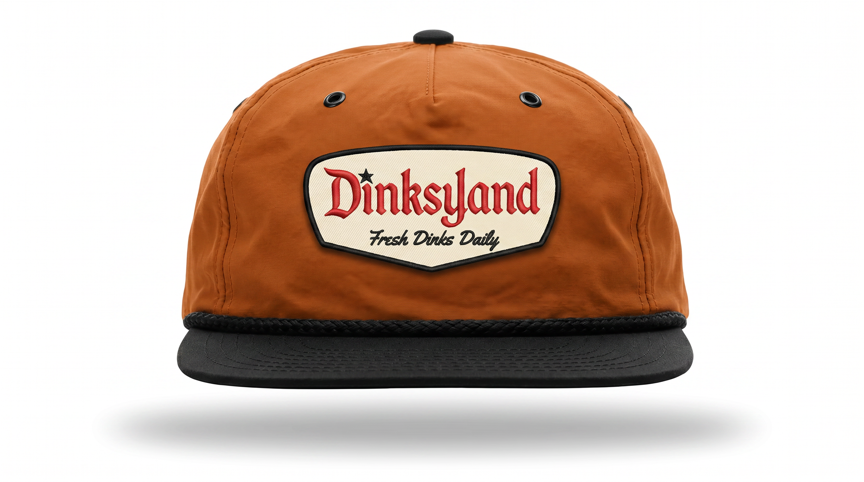 Tuxedo — Dark Orange Richardson 256 rope cap with black rope and a cream embroidered Dinksyland patch with a black border.
